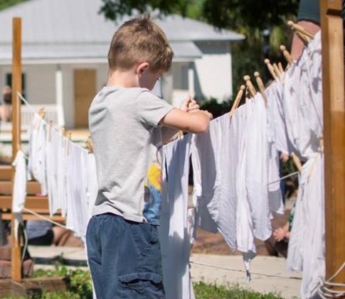 School children drying laundry during Palmetto Historical Park field trip program